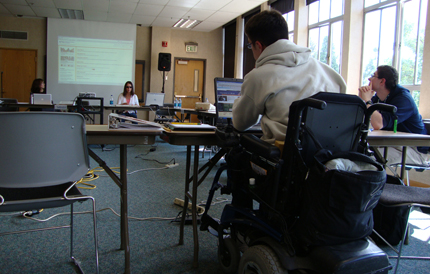 Student in a wheelchair uses a laptop during class.