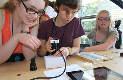 Three students use EXO labs computer equipment Three students use EXO labs computer equipment