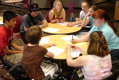 A group of students with disabilities sits around a table