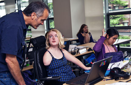 Technology Specialist answers a student's question in computer lab Technology Specialist answers a student's question in computer lab