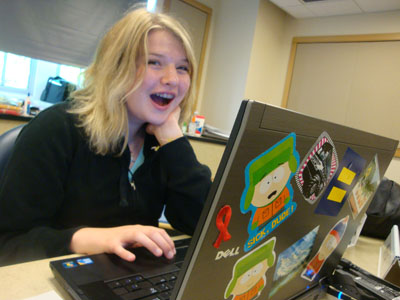 A student using a computer smiles