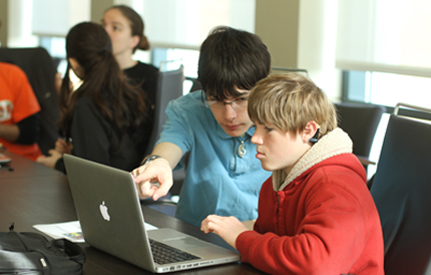 A student who is hearing impaired works on a computer project with another student. A student who is hearing impaired works on a computer project with another student.